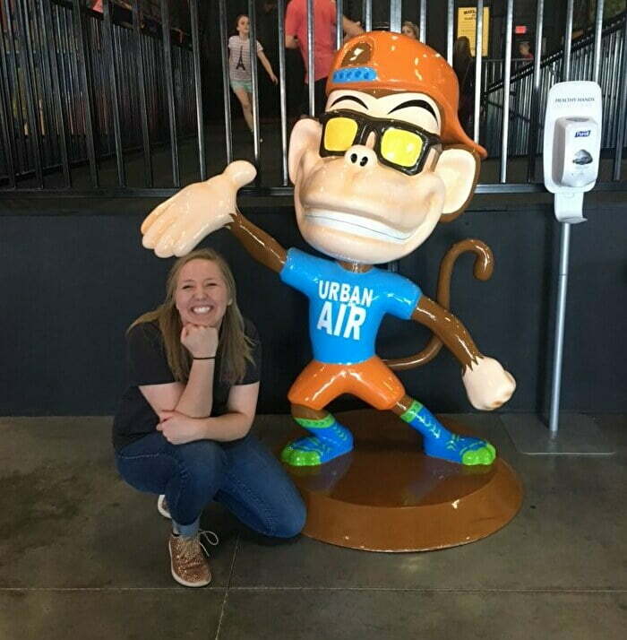 Young woman posing with monkey statue at Urban Air Trampoline Park in Oklahoma